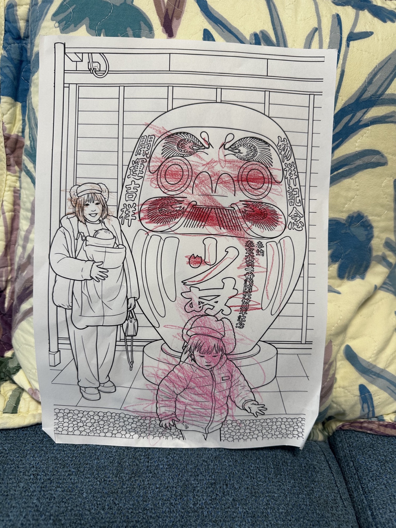 だるまの前で撮影した家族写真をもとにした塗り絵